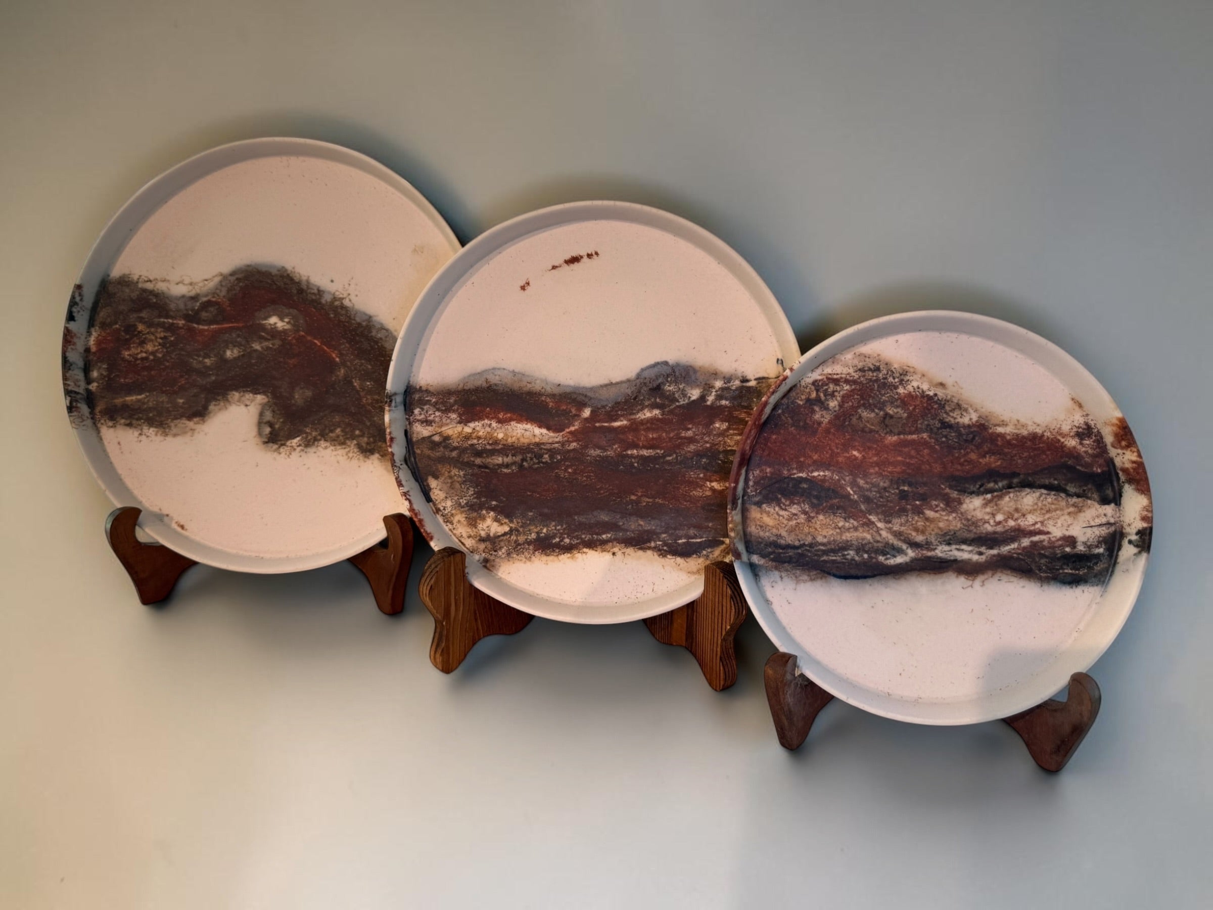 Echoes of Fire nesting plates, three plates on wooden stands